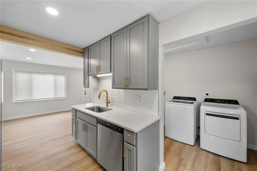 Kitchen with tasteful backsplash, stainless steel appliances, gray cabinetry, light stone countertops, and recessed lighting