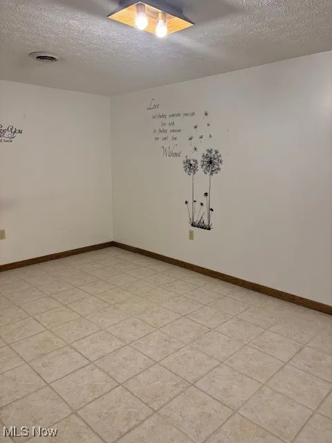 Rec  room featuring a textured ceiling and ceramic tile floors