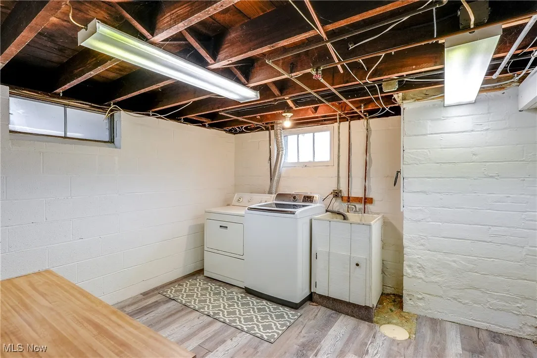 Laundry room featuring light vinyl flooring, clothes dryer (washer not included), sink, and folding counter.