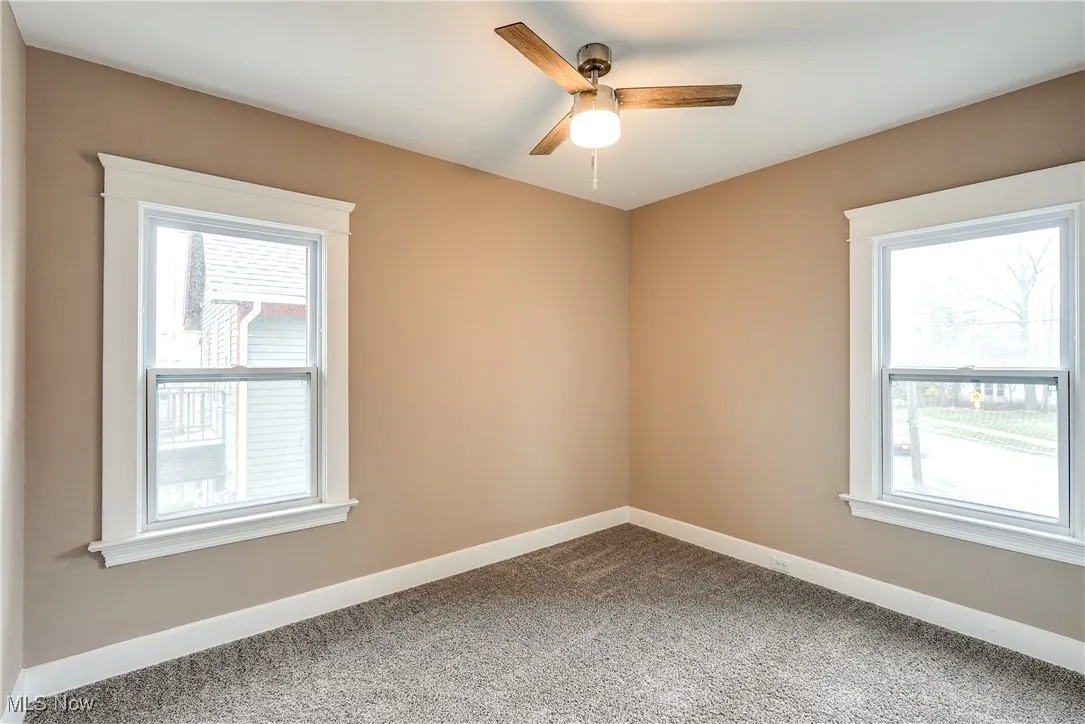 Carpeted bedroom with baseboards and a ceiling fan