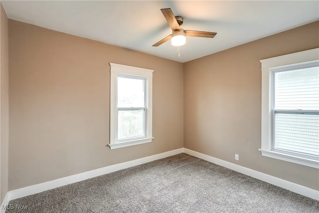 Carpeted bedroom with plenty of natural light, large closet, and a ceiling fan