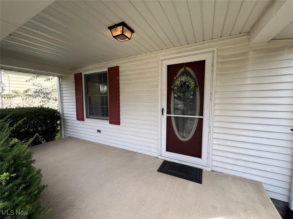 View of exterior entry featuring covered porch