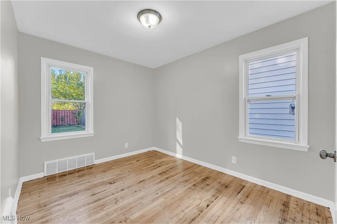 Spare room featuring light wood-style flooring and baseboards