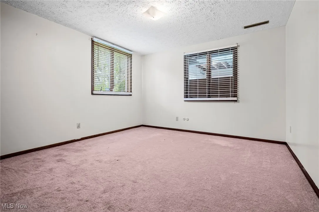 Spare Bedroom featuring carpet and a textured ceiling