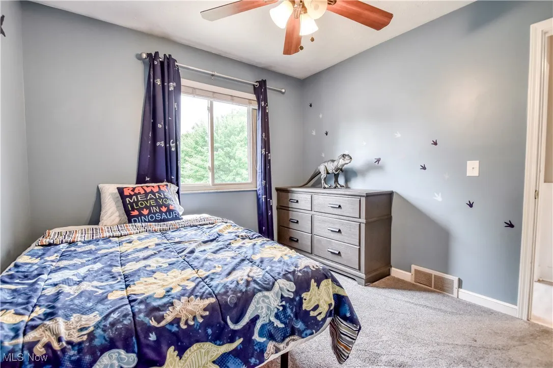 Bedroom featuring light colored carpet and a ceiling fan