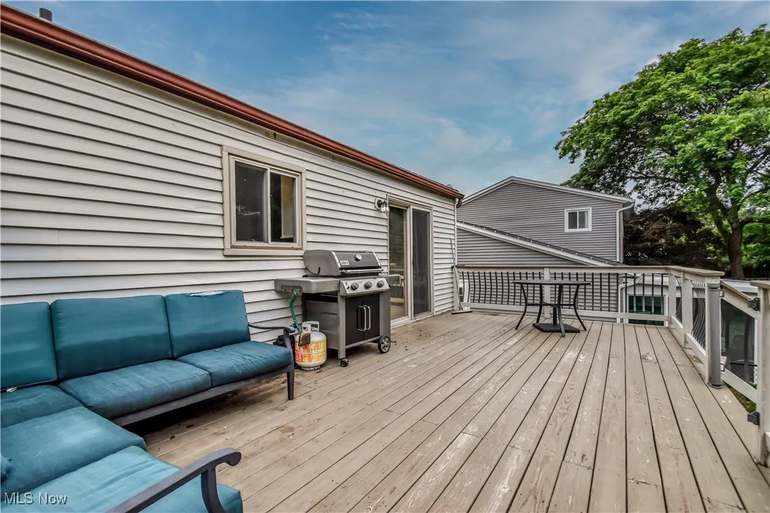 Wooden deck with an outdoor living space and area for grilling