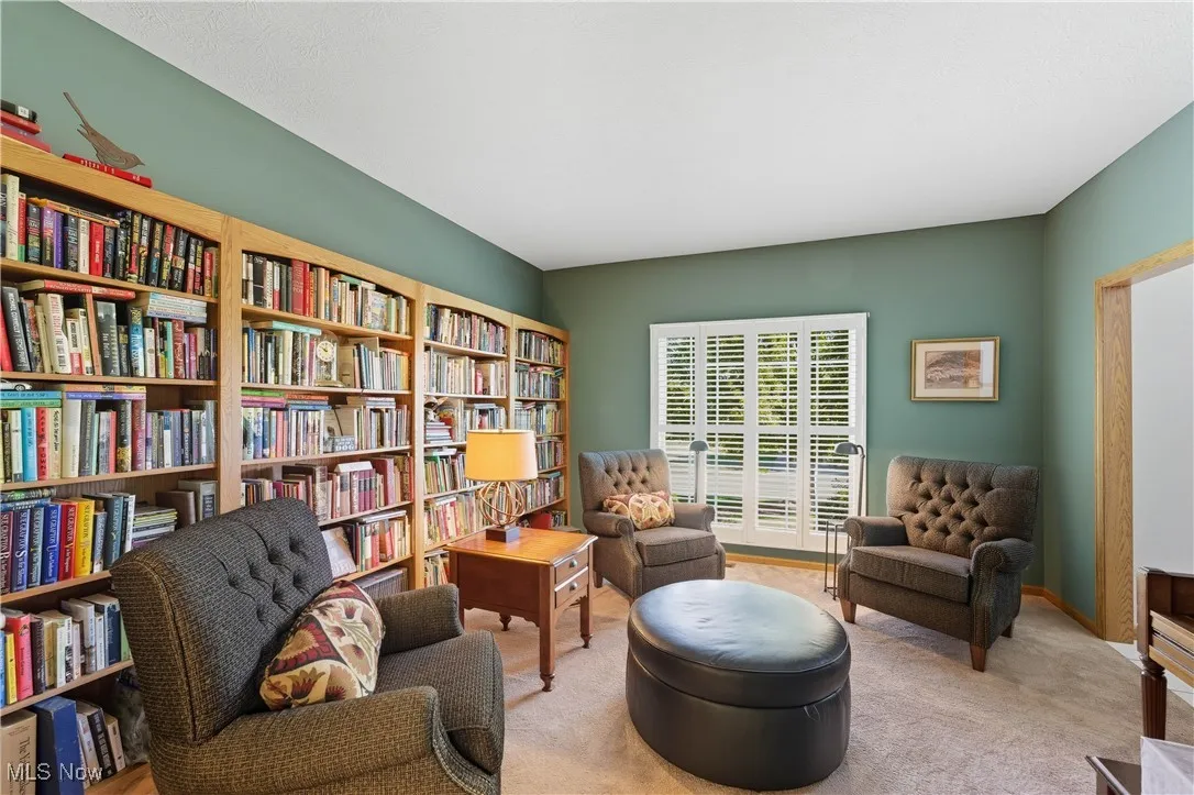 Sitting room featuring carpet floors and wall of books