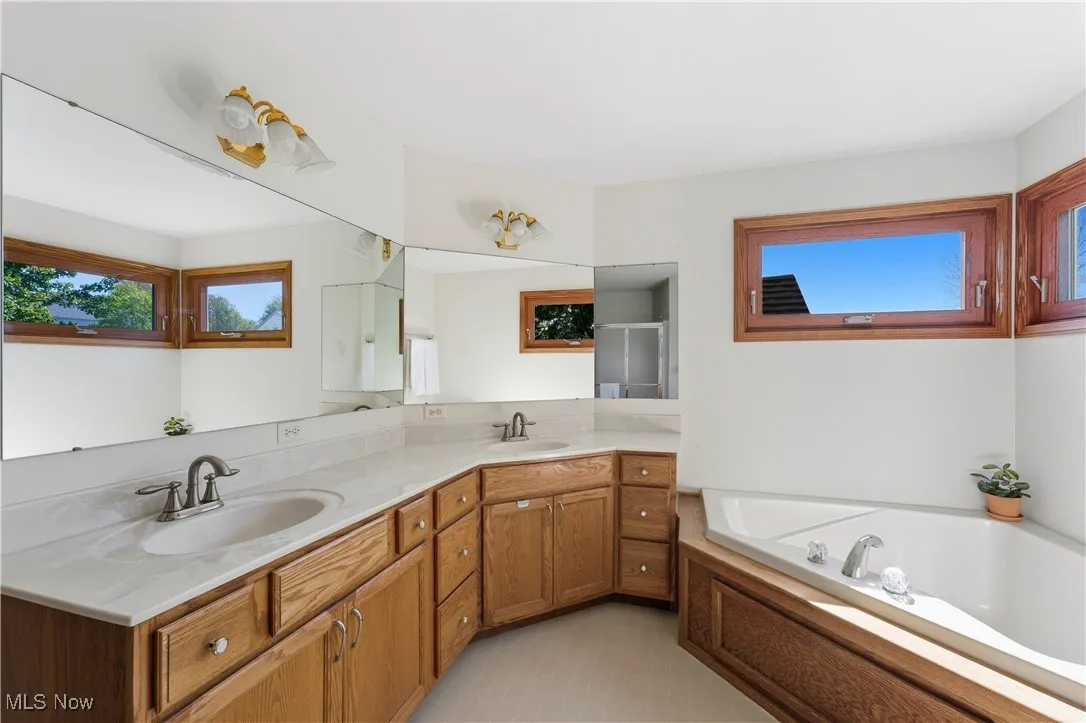 Full bath featuring double vanity and a bath