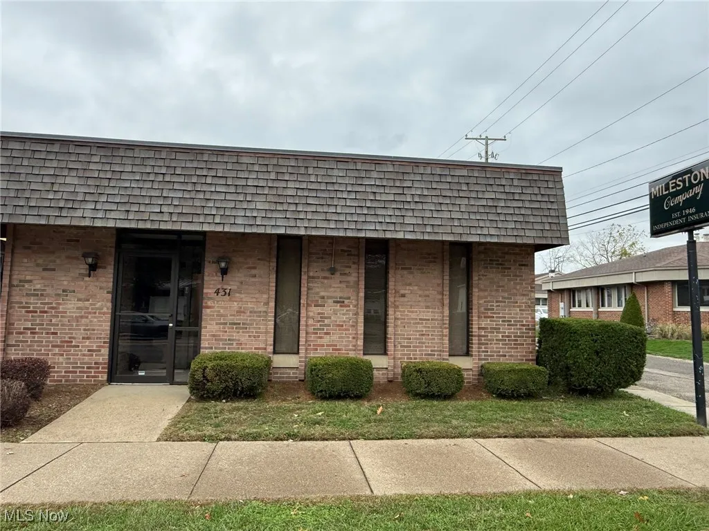 View of front of property with brick siding and mansard roof