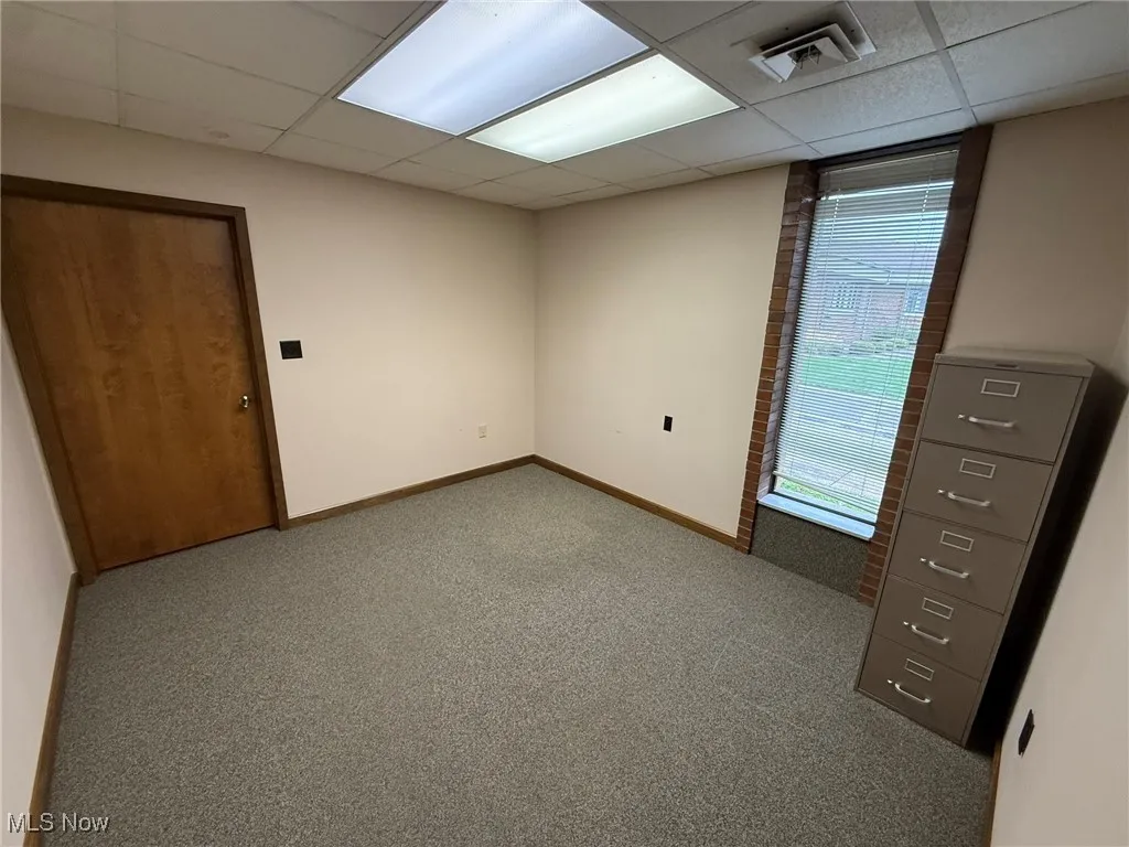 Unfurnished room with carpet flooring and a paneled ceiling