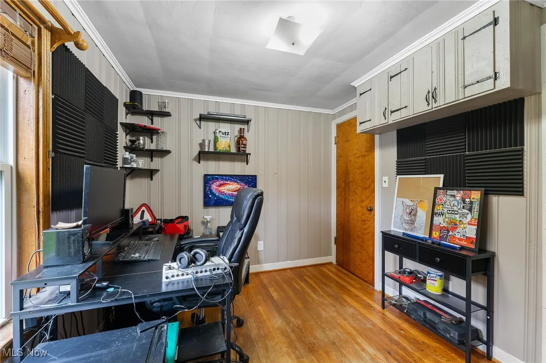 Office area featuring light wood finished floors and crown molding