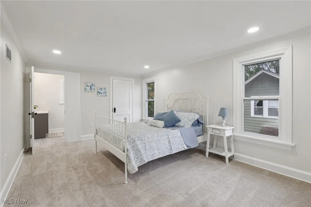 Bedroom with light colored carpet, recessed lighting, and crown molding