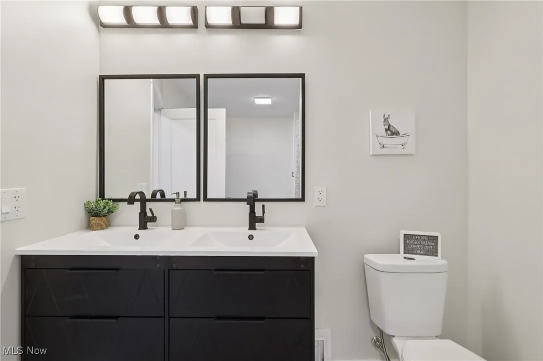 Full bath featuring double vanity and toilet