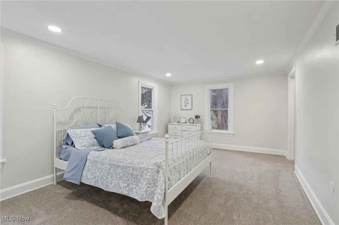 Bedroom featuring light carpet, ornamental molding, and recessed lighting