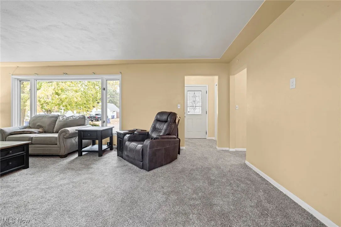Living area with light colored carpet and healthy amount of natural light