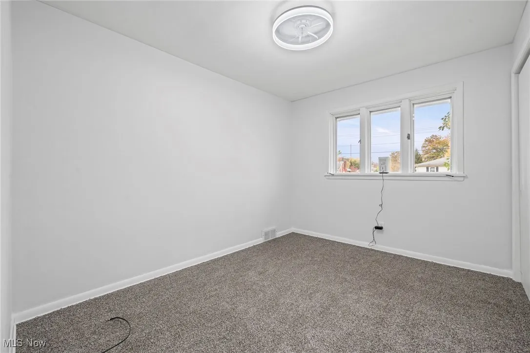 Unfurnished room featuring baseboards and carpet