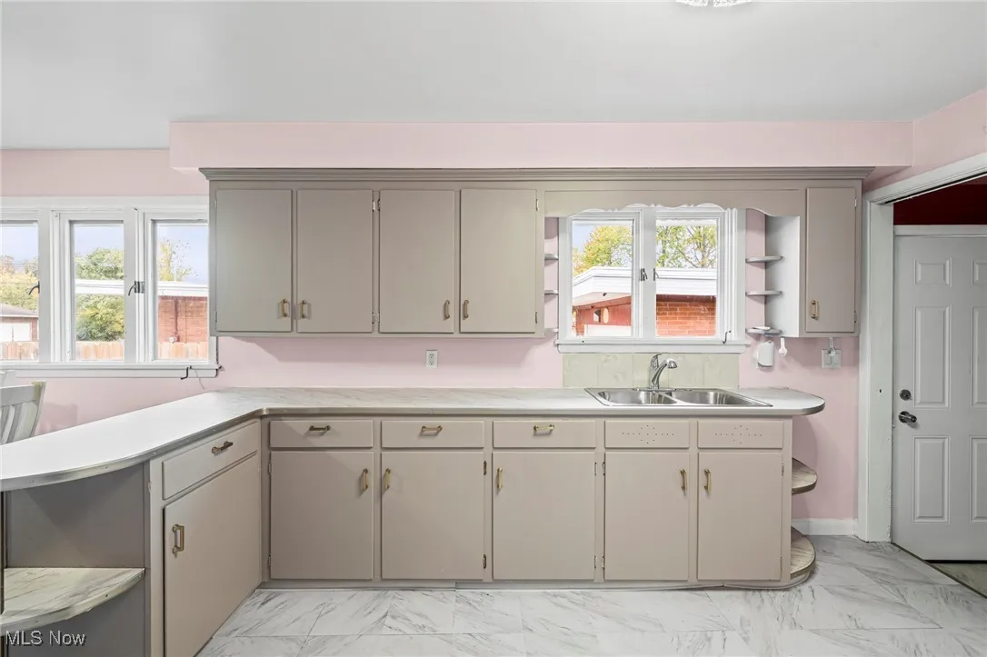 Kitchen with open shelves, light marble finish floors, and light countertops