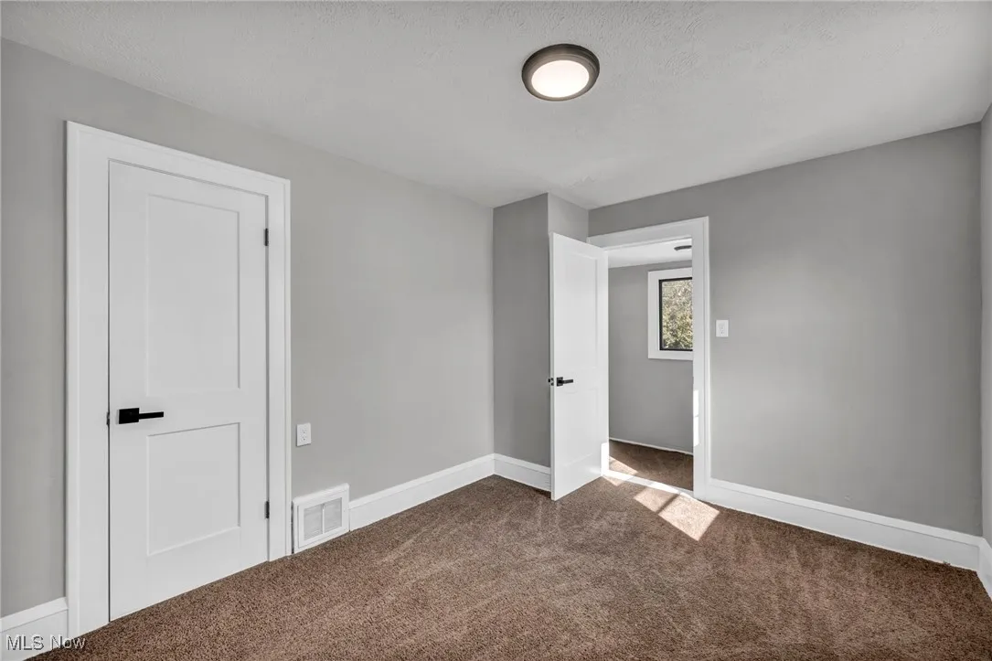 Unfurnished bedroom featuring carpet flooring and a textured ceiling