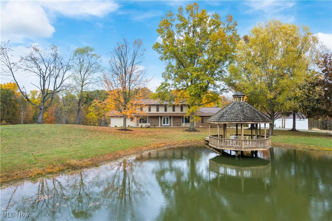 Dock area with a water view, a lawn, and a gazebo