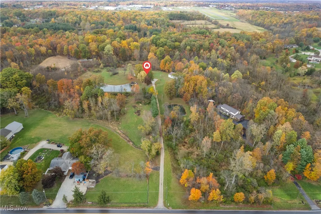 Aerial overview of property's location with a large body of water and a forest