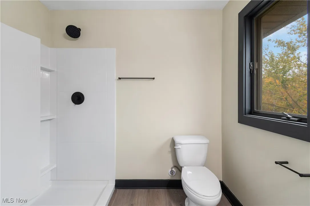 Full bath featuring a shower and wood finished floors