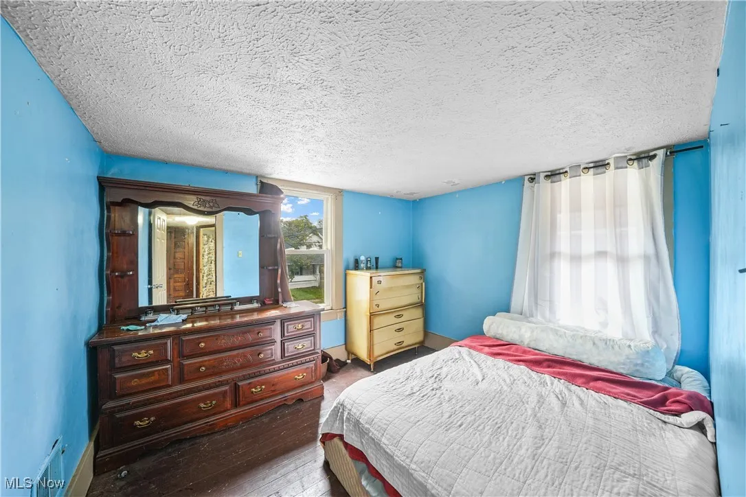 Bedroom with hardwood / wood-style flooring and a textured ceiling