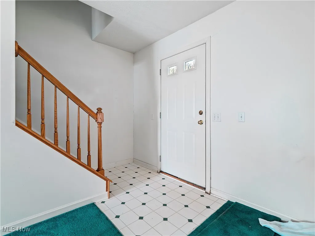 Foyer with baseboards and stairs