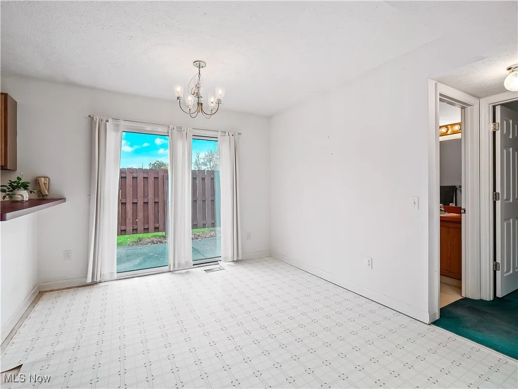 Unfurnished dining area with a textured ceiling and a chandelier
