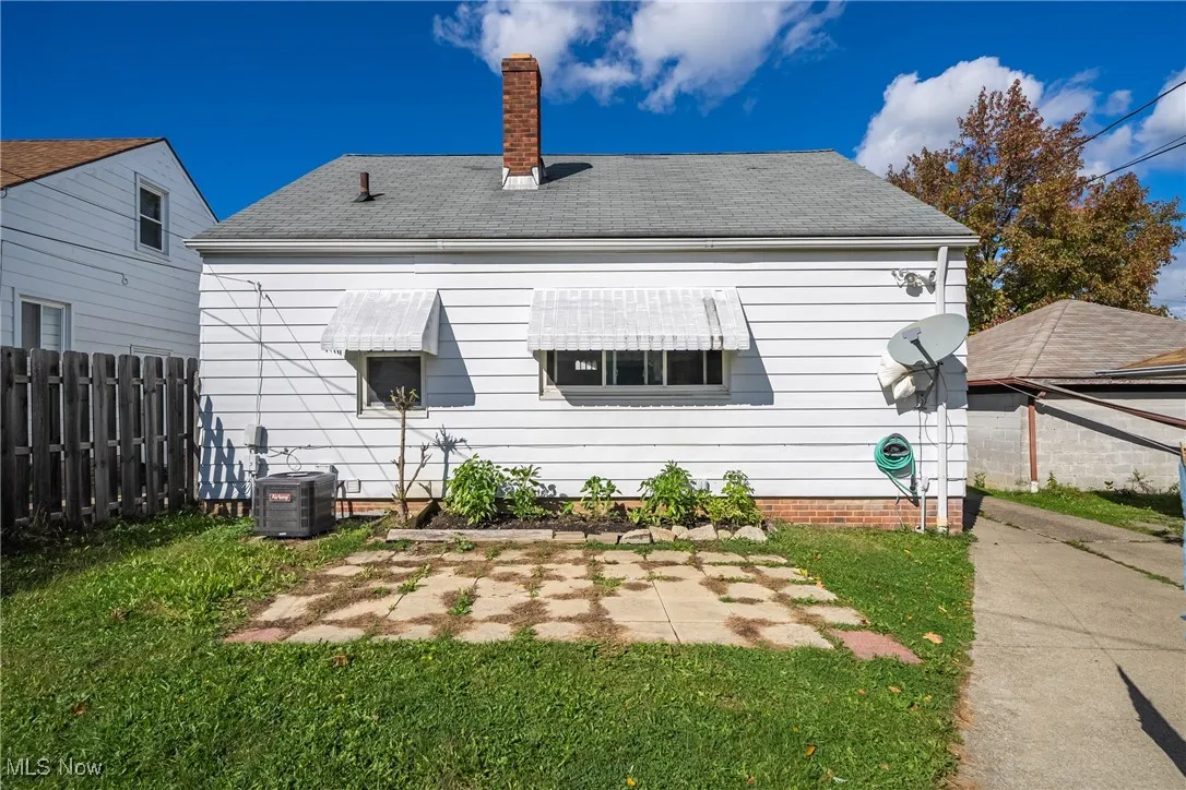 Rear view of property featuring a chimney and roof with shingles