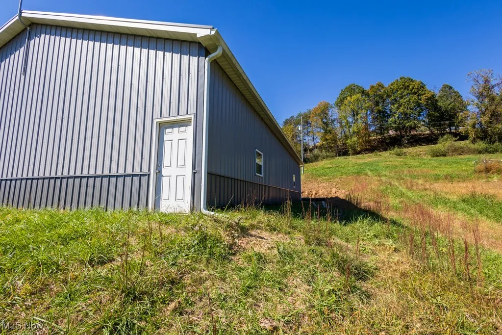 View of side of home with a pole building and an outbuilding