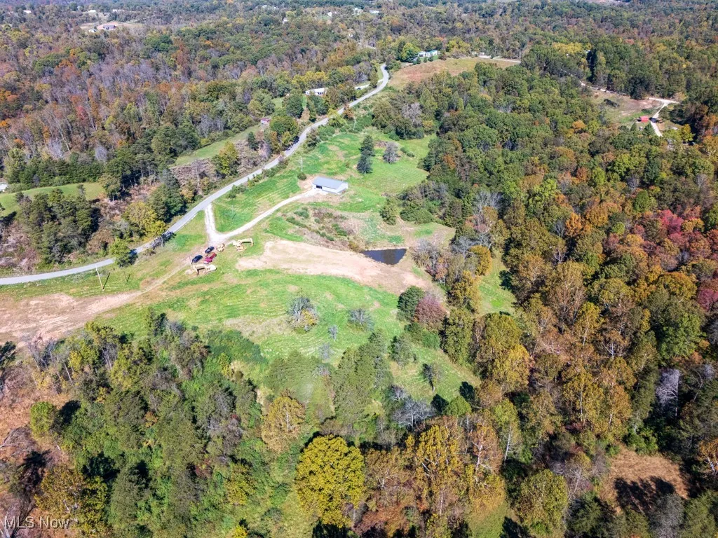 Aerial view of property's location with a heavily wooded area