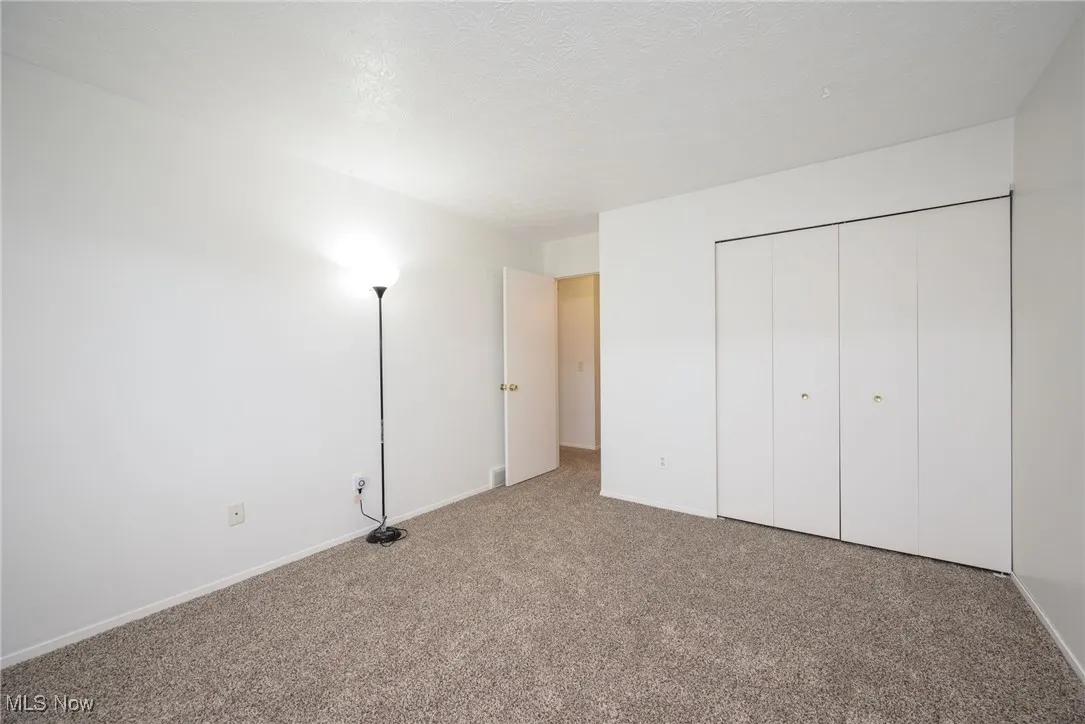 Unfurnished bedroom with a closet, carpet flooring, and a textured ceiling