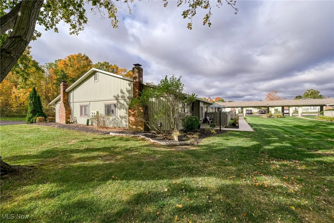 View of side of home featuring a yard and a chimney