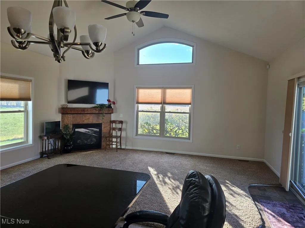 Vaulted great room with corner gas fireplace, patio door to patio and rear yard, eating area open to kitchen.