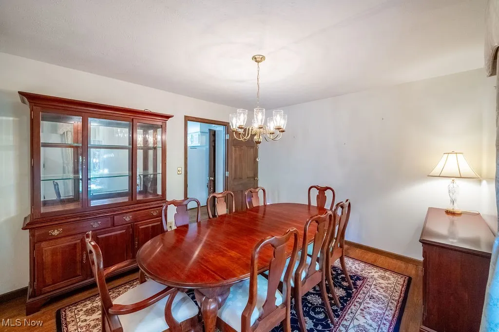 Dining area featuring wood finished floors and a chandelier
