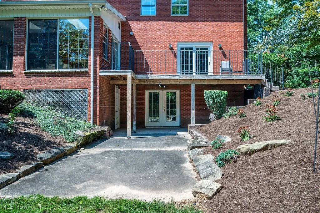 View of exterior entry with a patio area, french doors, and brick siding