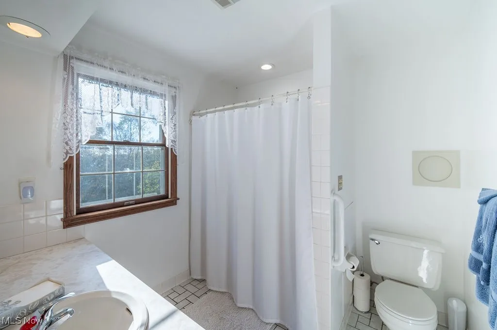 Full bath featuring vanity, a shower with curtain, recessed lighting, and light tile patterned floors