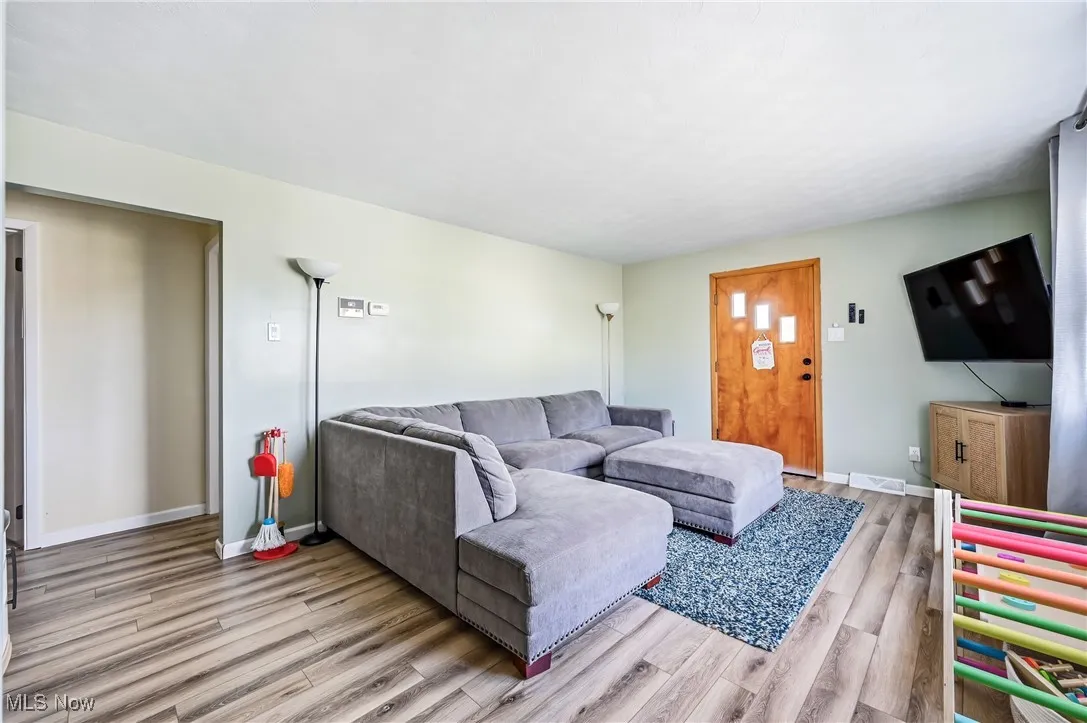 A cozy living room featuring newer lvt flooring with neutral colors & an open canvas