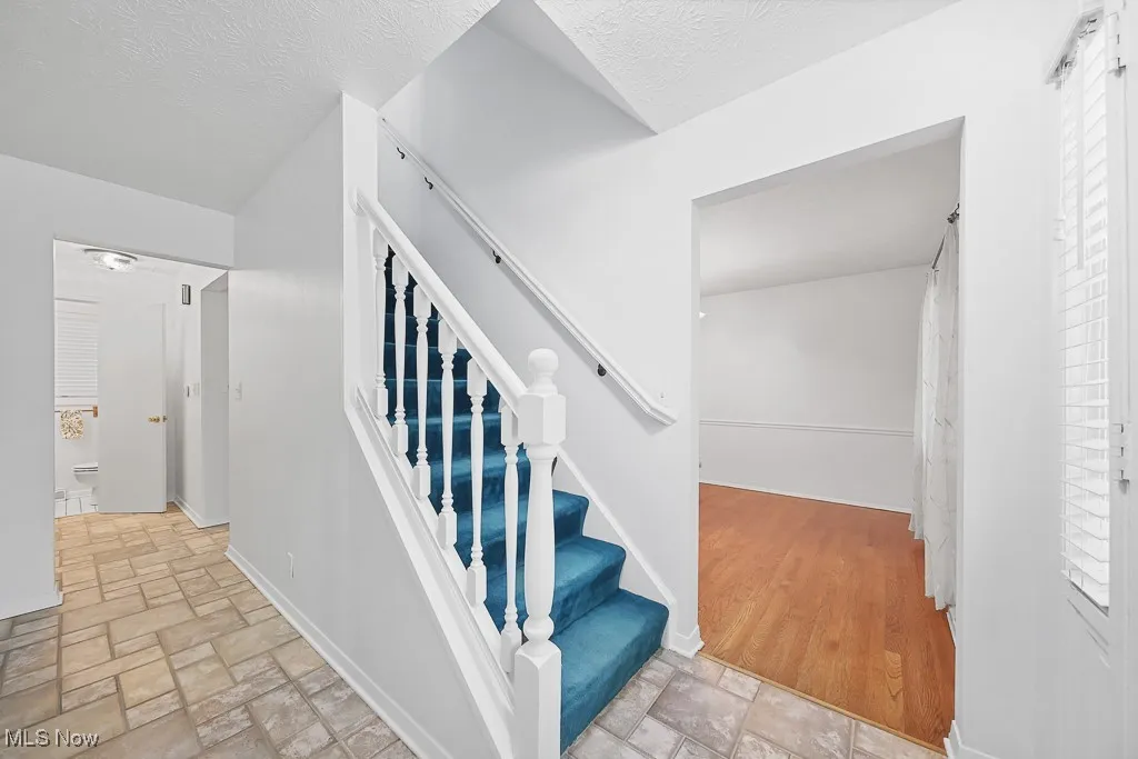Stairway with stone tile flooring and baseboards