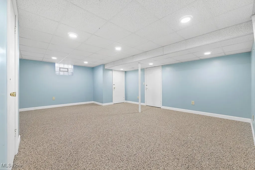 Basement with recessed lighting and a paneled ceiling