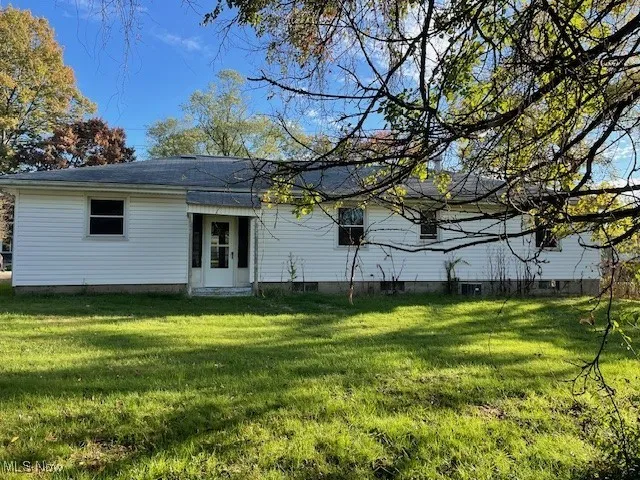 Back of property with a lawn