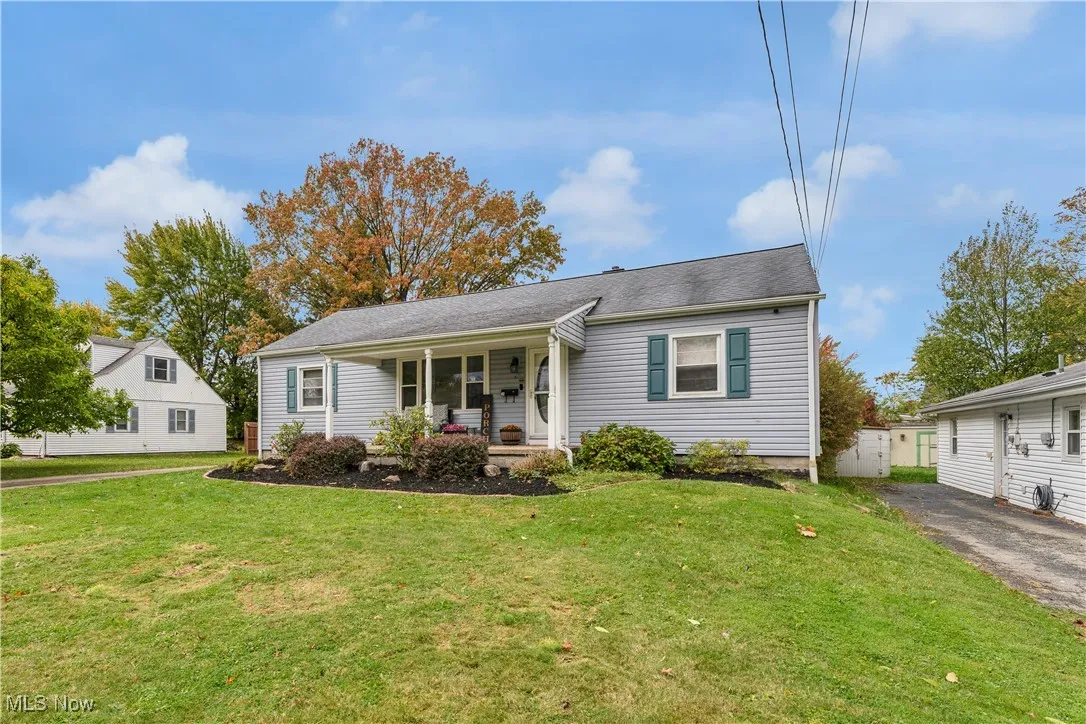 Bungalow-style house with a front lawn, a shingled roof, and covered porch