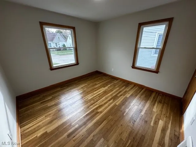 Spare room with plenty of natural light and wood finished floors