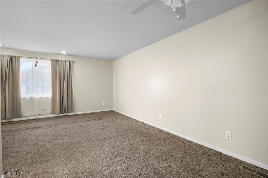 Carpeted empty room featuring baseboards