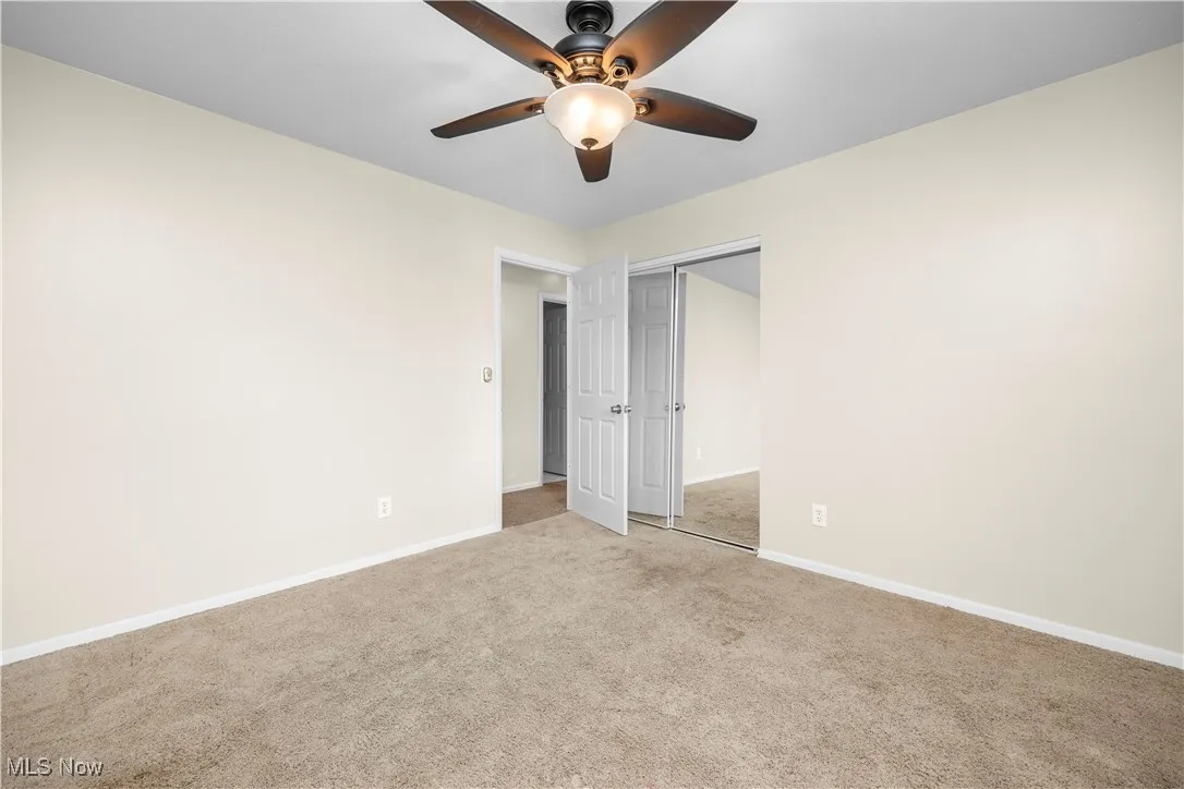 Unfurnished bedroom featuring carpet, a closet, and a ceiling fan