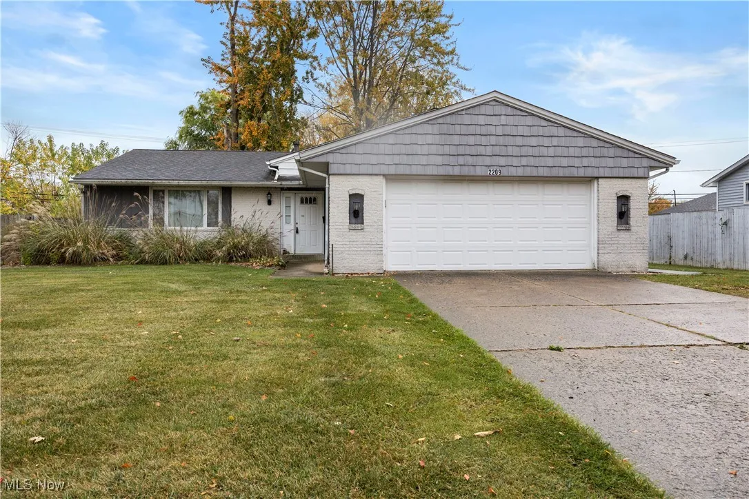 Split level home with brick siding, driveway, and an attached garage