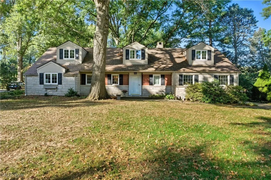 New england style home with a front lawn and a chimney