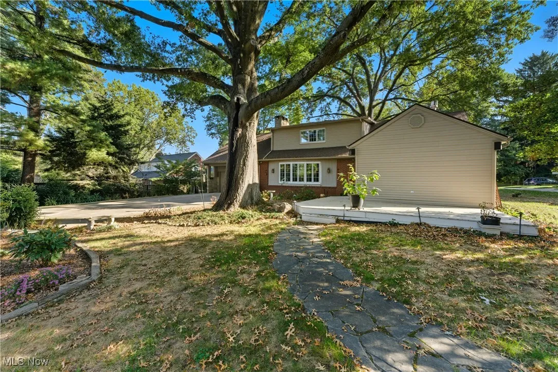 View of front of home featuring a chimney, a front yard, and concrete driveway