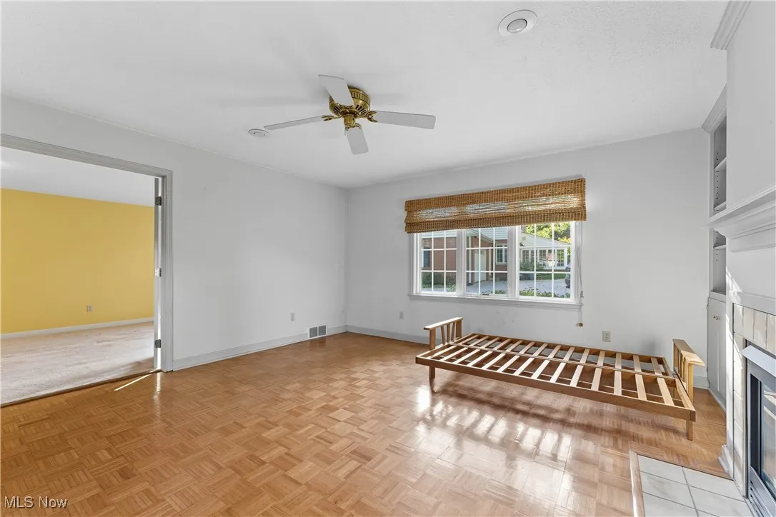 Living area with a fireplace and ceiling fan