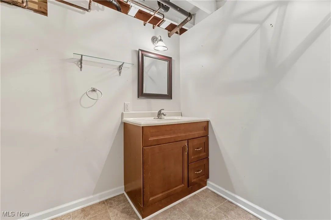 Half bathroom with vanity and light tile patterned flooring